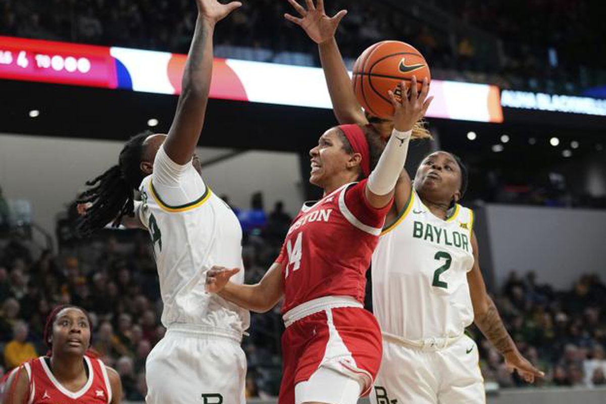 Two Baylor defenders jump in an effort to block the shot of the Houston player.