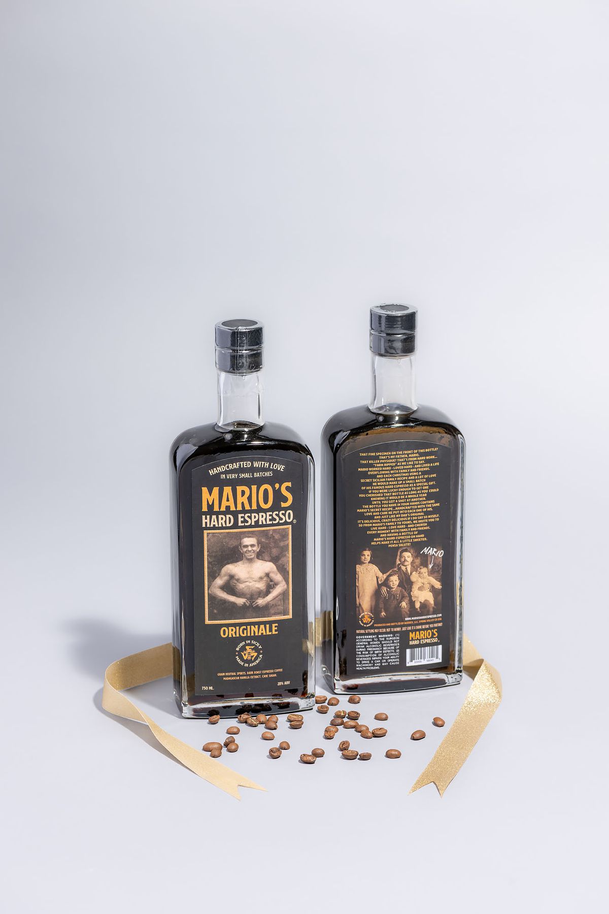 Two bottles of coffee liqueur with a boxer on the label from Mario’s Hard Espresso surrounded by coffee beans and a gold ribbon.