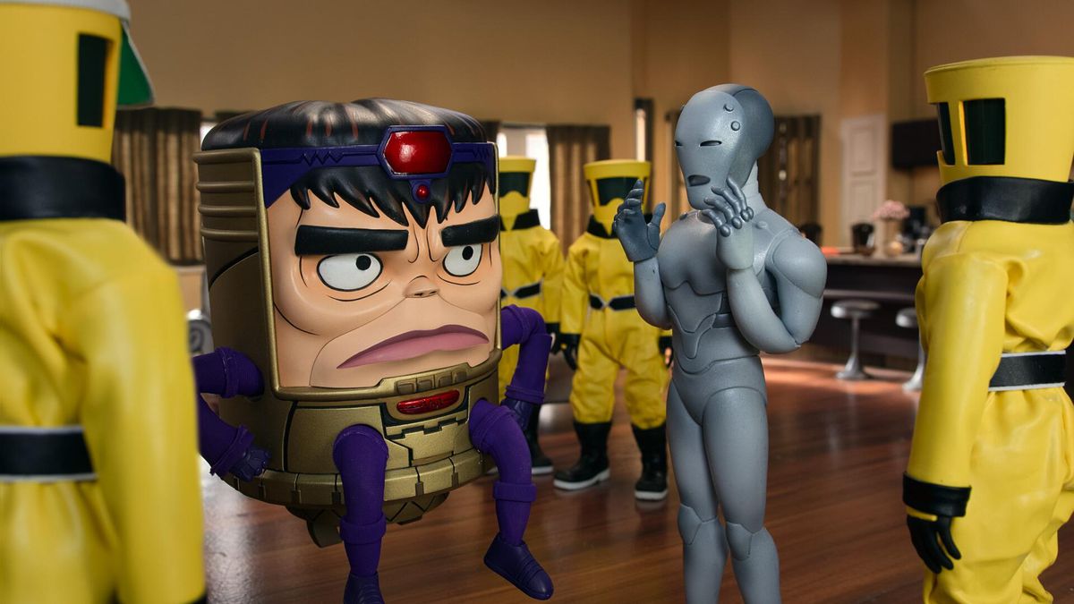 M.O.D.O.K. talks to the Super-Adaptoid in a room full of yellow-suited minions