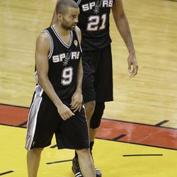 The San Antonio Spurs' Tony Parker (9) and Tim Duncan (21) walk on the court during the second half in Game 7 of the NBA basketball championship against the Miami Heat, Thursday, June 20, 2013, in Miami. The Miami Heat won 95-88. 