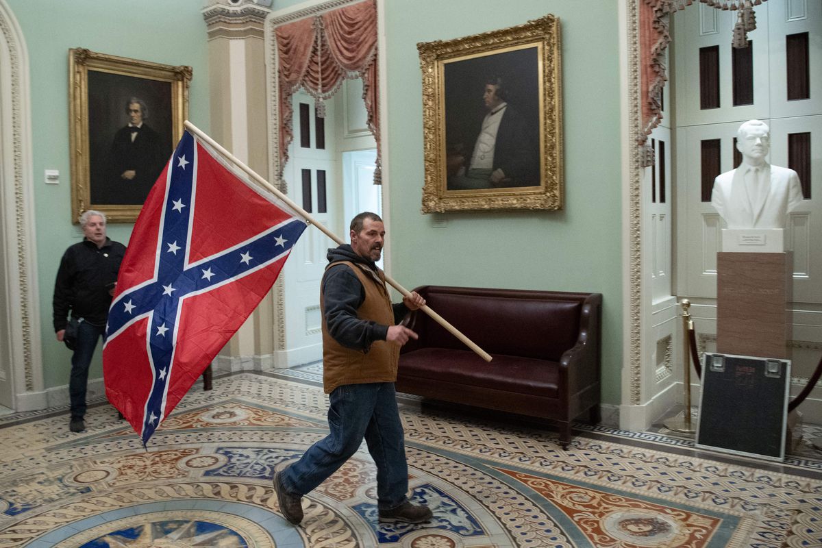A Trump supporter carries a Confederate flag in the Capitol Rotunda, which was breached by a mob on January 6, 2021.