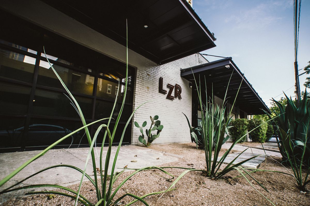 Photo of white brick building with canopy overhangs and “LZR” signage