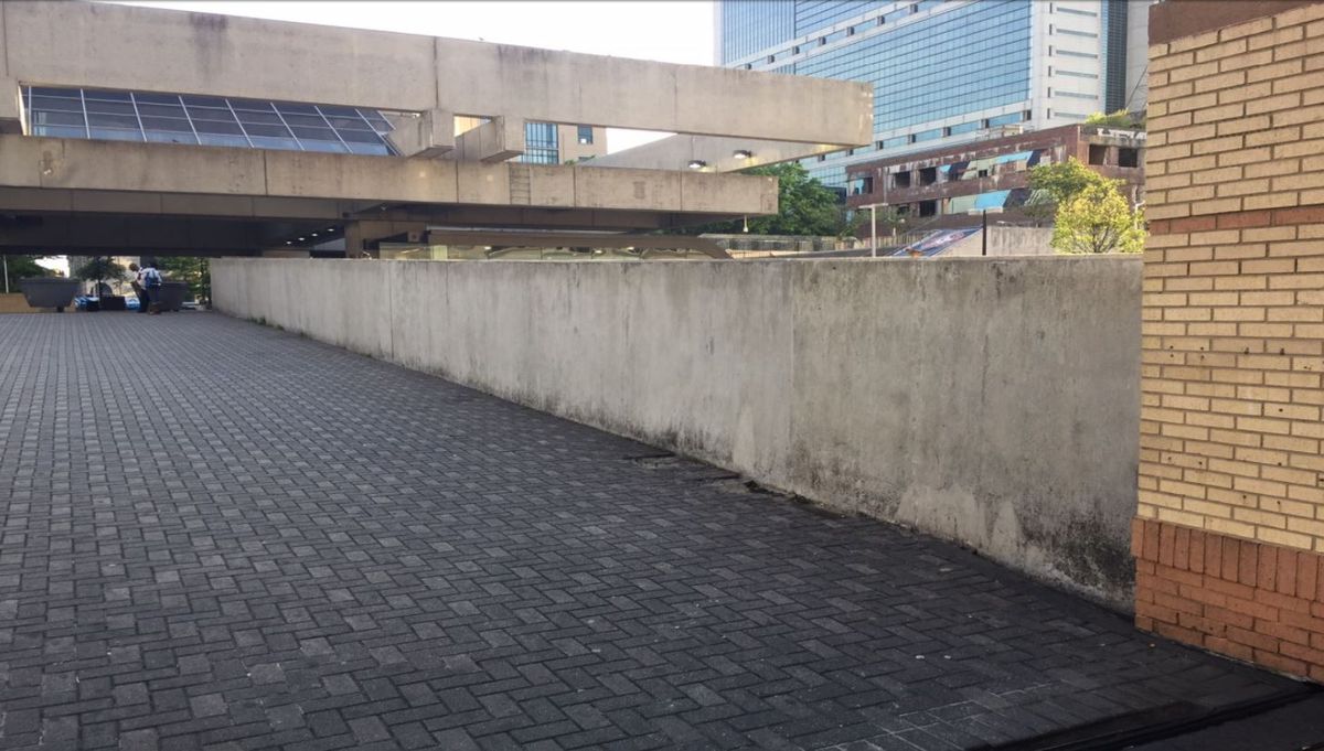 A long concrete wall leading to the Five Points MARTA Station.