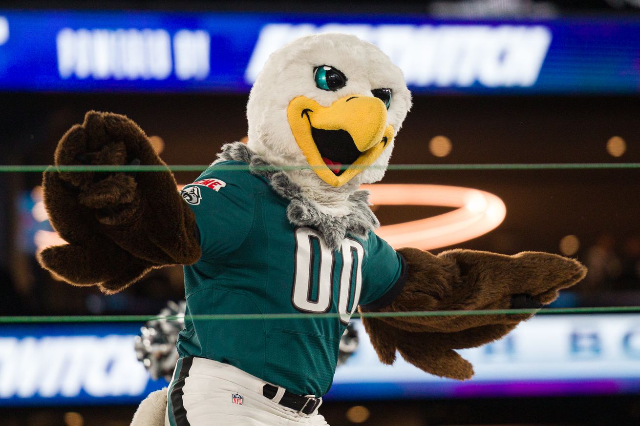 Person in Eagles costume dances with a crowd in background