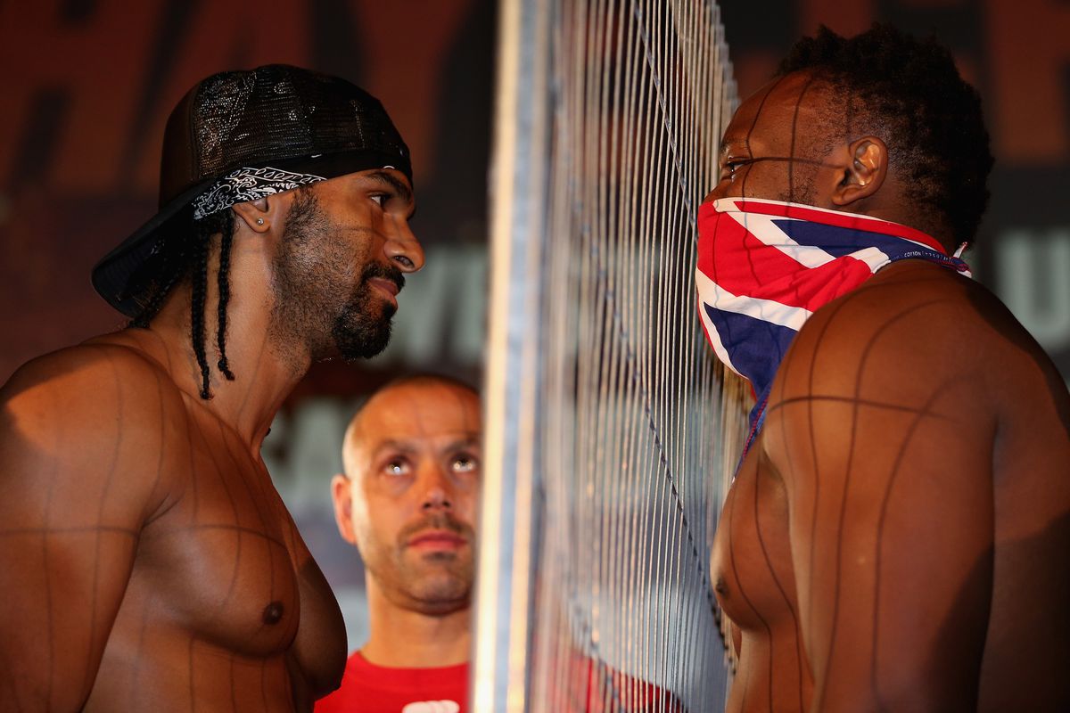 David Haye (left) and Dereck Chisora eyeball each other as Haye's trainer Adam Booth (centre) looks on during the Weigh-In at The Odeon Leicester Square on July 12, 2012 in London, England. (Photo by Andrew Redington/Getty Images)