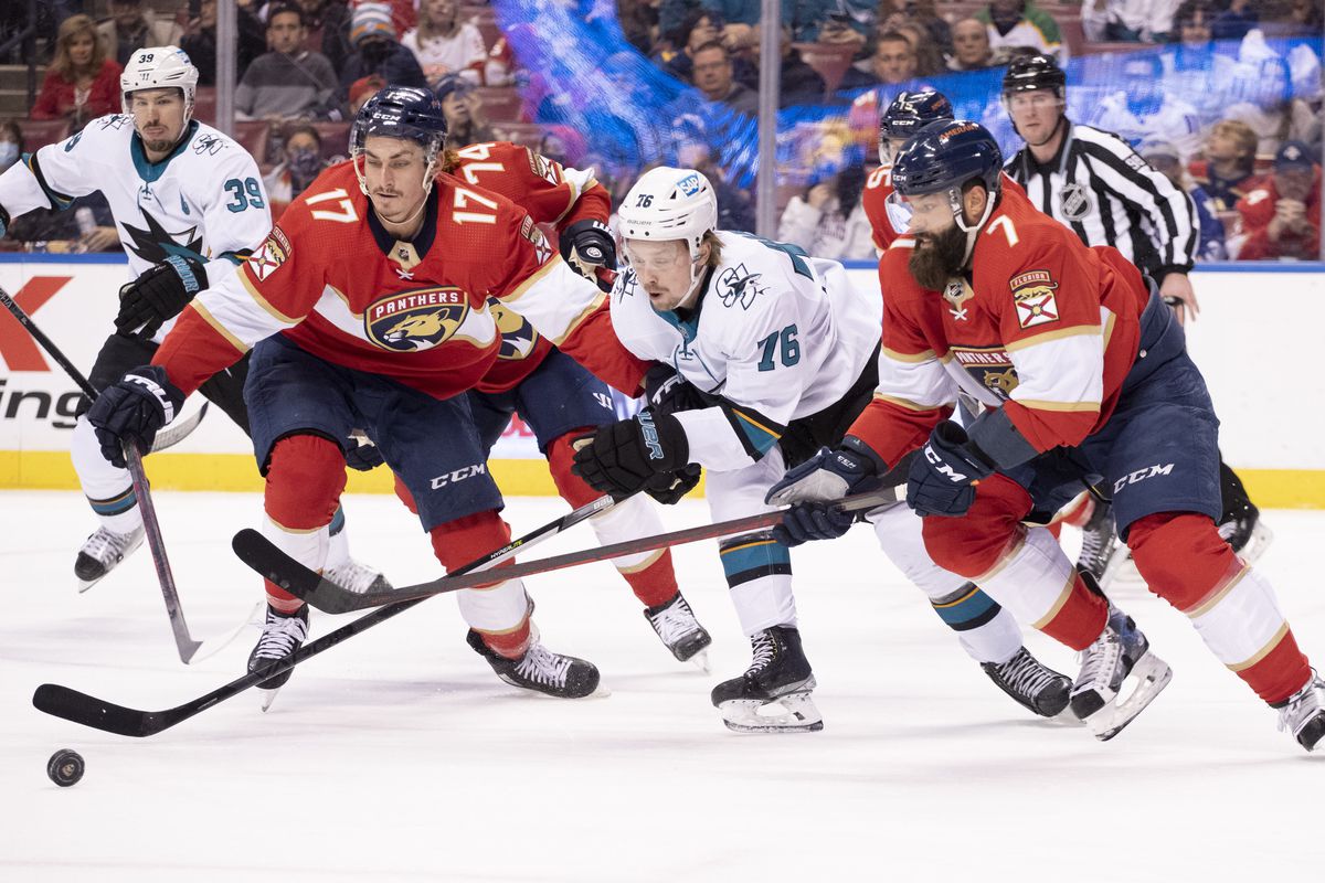 Florida Panthers left wing Mason Marchment (17) and defenseman Radko Gudas (7) battle for the puck against San Jose Sharks center Logan Couture (39) and center Jonathan Dahlen (76) during the first period at FLA Live Arena.