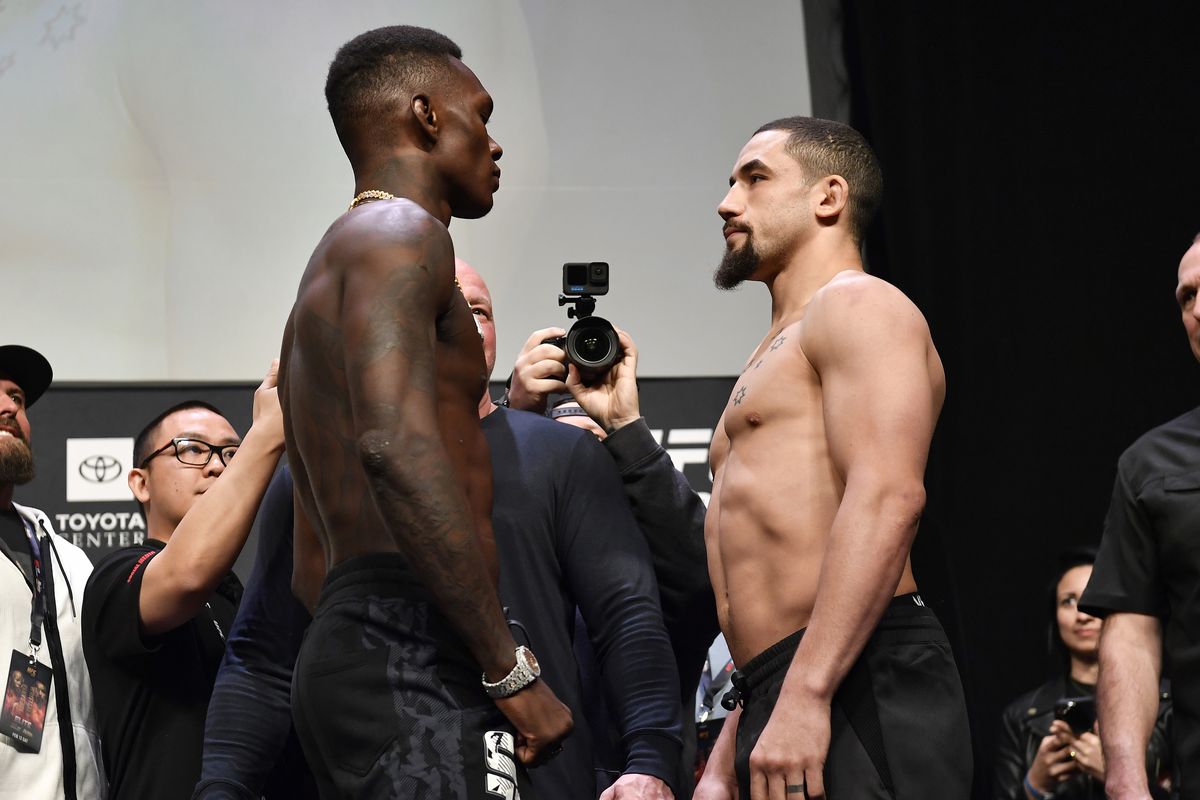  Israel Adesanya of Nigeria and Robert Whittaker of Australia face off during the UFC 271 ceremonial weigh-in at Toyota Center on February 11, 2022 in Houston, Texas.