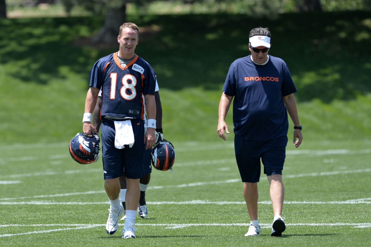 Denver Broncos quarterback Peyton Manning and QB Coach Greg Knapp walk off the field during minicamp practice on June 11, 2013.