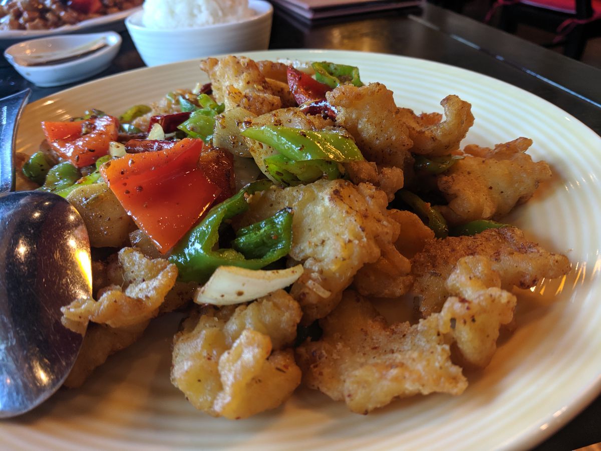 A platter of fried fish topped with peppers
