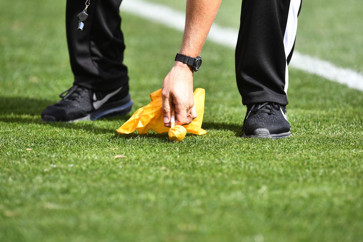 Detailed view of NFL referee picking up a penalty flag during the game between the Seattle Seahawks against the Denver Broncos at Broncos Stadium at Mile High.