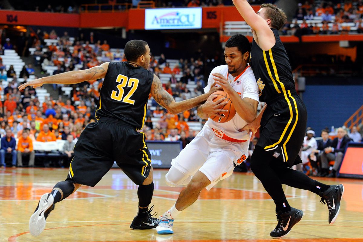 Nov 10, 2014; Syracuse, NY, USA; Syracuse Orange guard Michael Gbinije (center) drives to the basket between Adrian Bulldogs guard R'mand Harp (32) and Adrian Bulldogs guard Jamison Webster (right) during the first half at the Carrier Dome.