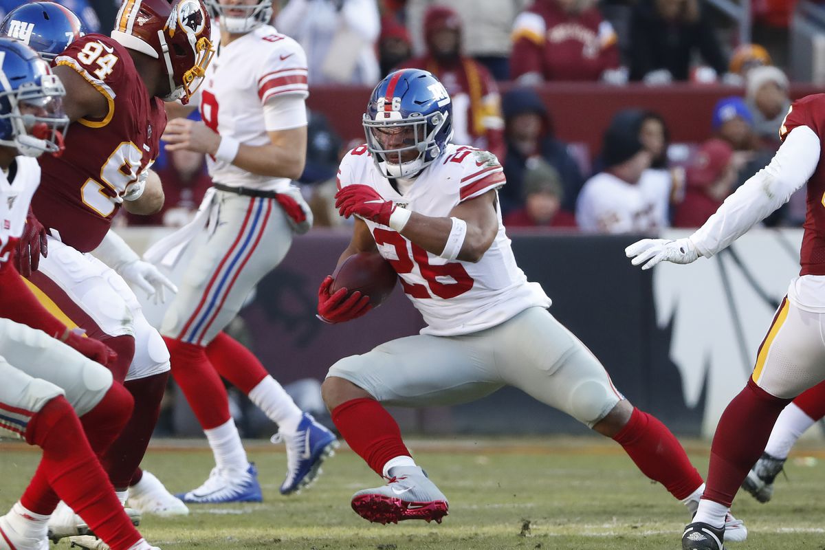 New York Giants running back Saquon Barkley carries the ball past Washington nose tackle Daron Payne in the second quarter at FedExField.