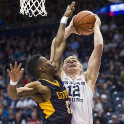 Brigham Young forward Eric Mika (12) fights to get a shot off against Coppin State forward Izais Hicks (11) during an NCAA college basketball game in Provo on Thursday, Nov. 17, 2016.