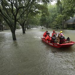A Coast Guard rescue team evacuates people from a neighborhood inundated by floodwaters from Tropical Storm Harvey on Monday, Aug. 28, 2017, in Houston, Texas. (AP Photo/Charlie Riedel)
