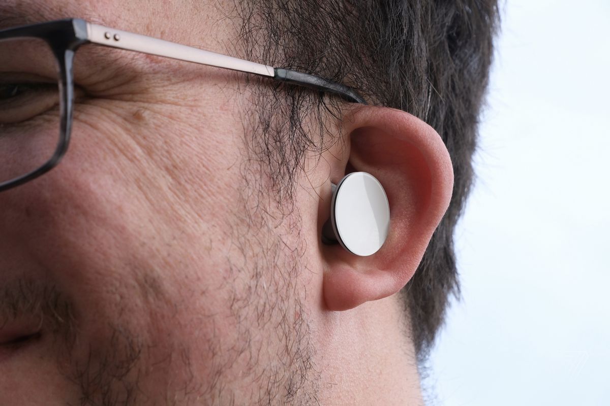 The Surface Earbuds pictured worn in the reviewer’s left ear.