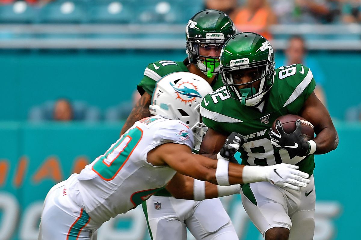New York Jets wide receiver Jamison Crowder carries the ball as Miami Dolphins free safety Reshad Jones makes the tackle during the first half at Hard Rock Stadium.