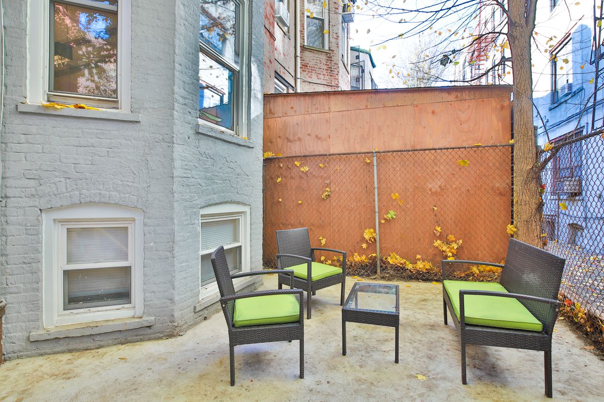 A patio with three chairs and a small coffee table.