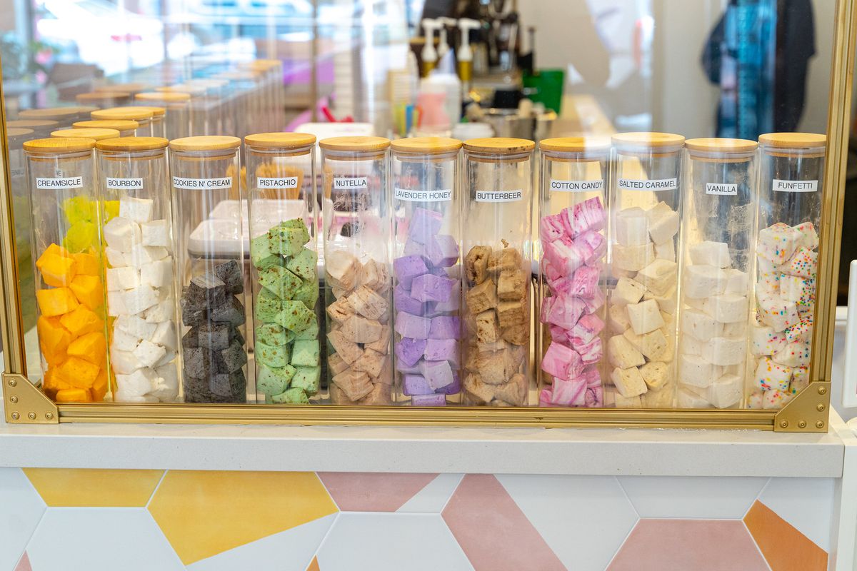 Canisters holding marshmallows in a variety of colors and flavors.