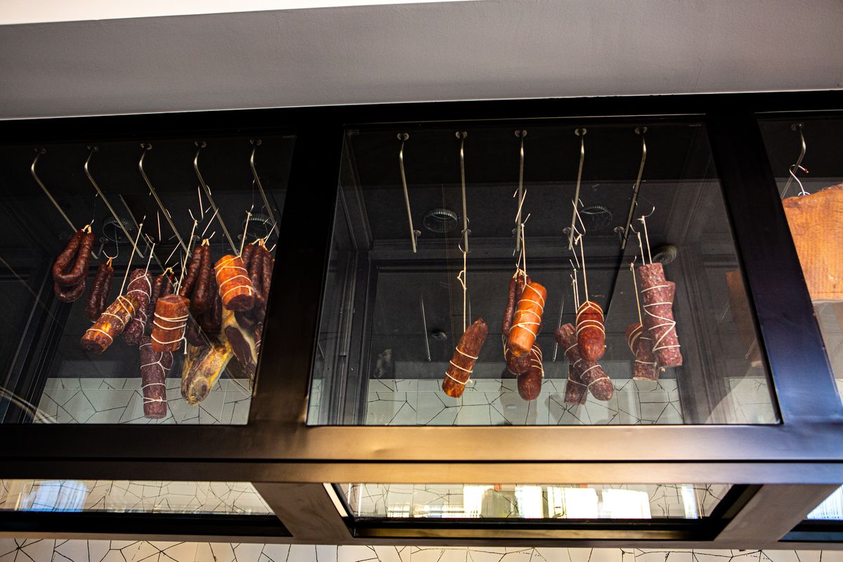 A restaurant display case of hanging meats.