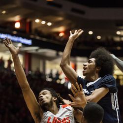 Utah State's Jalen Moore, right, tries for a basket against New Mexico's Jordan Goodman, left, during the first half of an NCAA college basketball game Saturday, Feb. 7, 2015, in Albuquerque, N.M. Utah State won 63-60. (AP Photo/Craig Fritz)