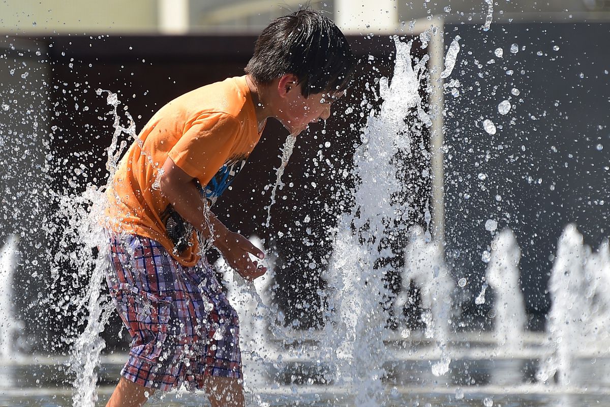Children cool off playing among water fountains at a downtown park in Los Angeles, California on May 14, 2014 where temperatures closed in on 100 degrees
