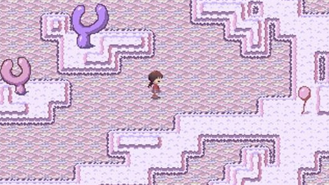 An image of Yume Nikki’s protagonist, Madotsuki. There is a top-down view of the screen and she’s walking around a dreamy and pink pixelated world. 