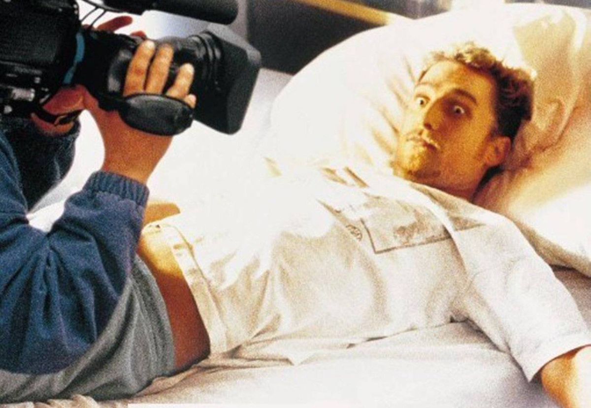 A wide-eyed Matthew McConaughey, lying in bed, looks up at a too-close camera lens in EDtv
