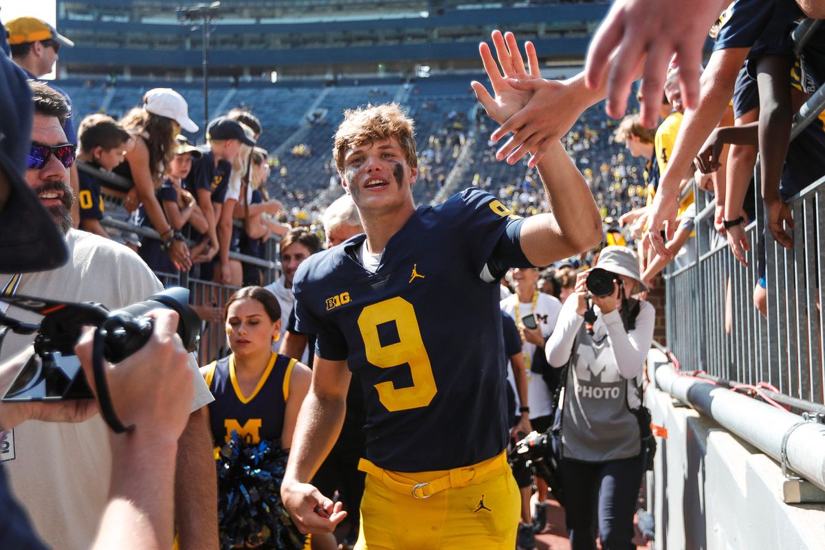 Michigan quarterback J.J. McCarthy high fives fans as he exits the field after the Michigan defeat Northern Illinois 63-10 at Michigan Stadium in Ann Arbor on Saturday, Sept. 18, 2021.