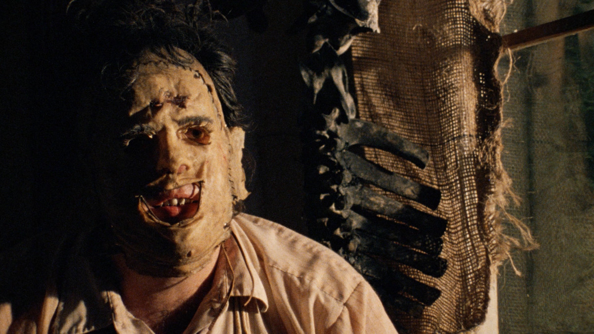 Leatherface is contemplative in The Texas Chainsaw Massacre, with a mask on his face