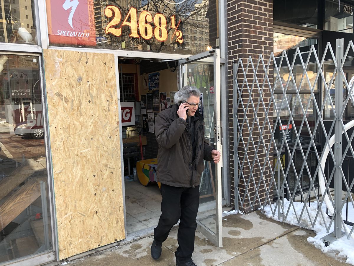 Mark Mattei walks past the boarded up window that thieves smashed early Tuesday to gain access to his Lincoln Park bicycle shop, Cycle Smithy. / Mitch Dudek for the Sun-Times