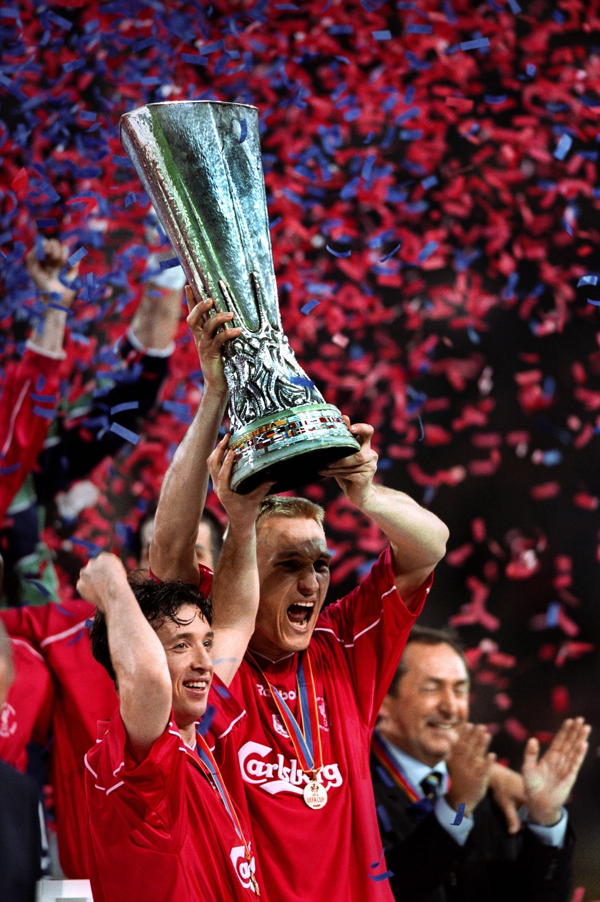Liverpool’s Robbie Fowler lifts the UEFA cup trophy with captain Sami Hyypia as manager Gerard Houllier celebrates in the background after winning one of the best cup finals in modern memory. &nbsp;  