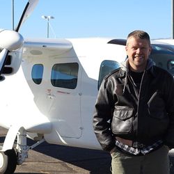 Alan Carver, 50, in front of a Cessna fixed-wing aircraft.