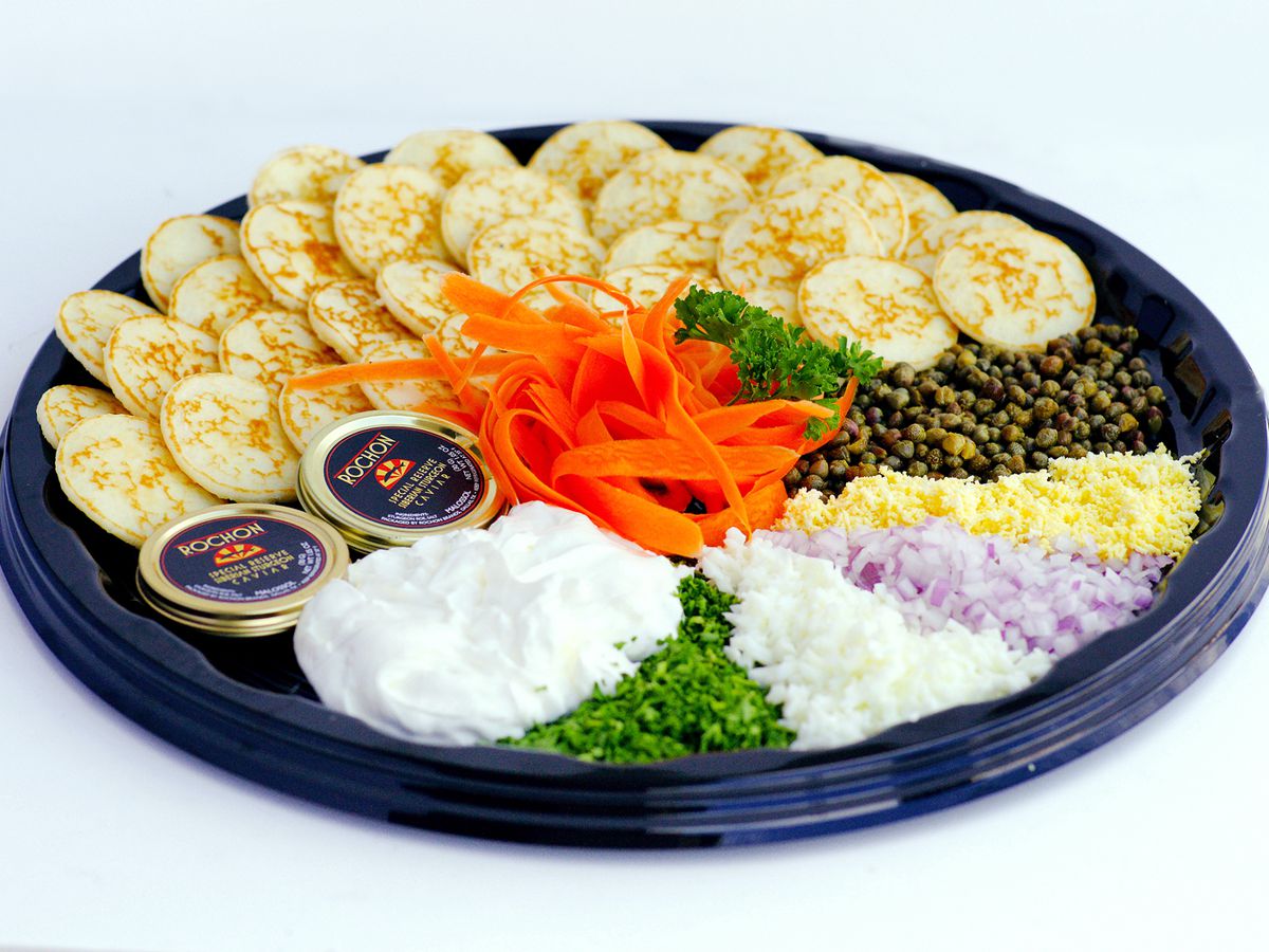 A platter with caviar, crackers, and other accoutrements. 