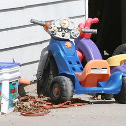 Children's toys can be seen in the yard of an American Fork home as police officers investigate a homicide Friday, April 5, 2013, at 582 N. 500 East.
