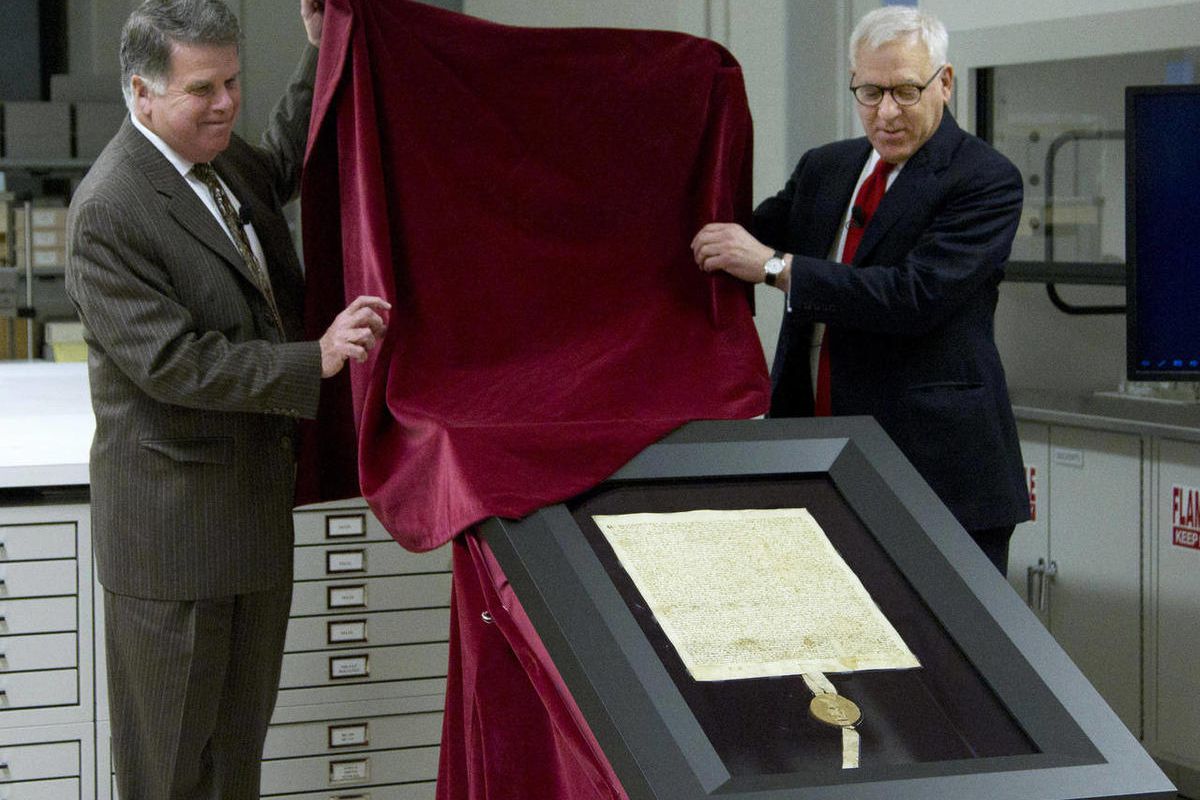 Carlyle Group co-founder and Magna Carta owner David Rubenstein, right, and Archivist of the U.S. David Ferriero, unveil the 1297 Magna Carta in its new state-of-the-art encasement at the National Archives in Washington, Thursday, Feb. 2, 2011.  