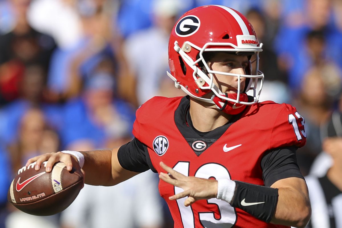 Stetson Bennett of the Georgia Bulldogs rolls out to pass in the first half against the Kentucky Wildcats at Sanford Stadium on October 16, 2021 in Athens, Georgia.