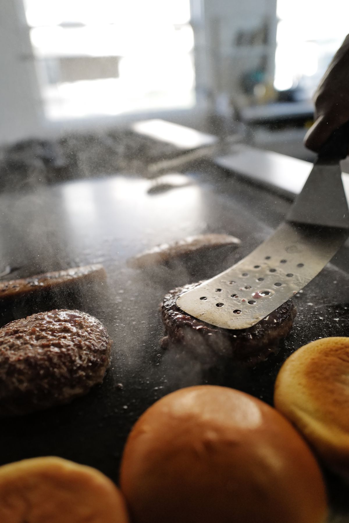 Cooking a burger on a flattop grill.