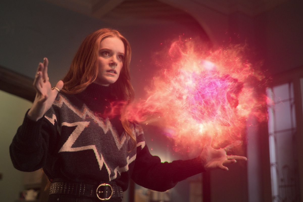 bloom, a redhaired fairy, holds her hands out, with a sphere of flames floating between them. she looks determined