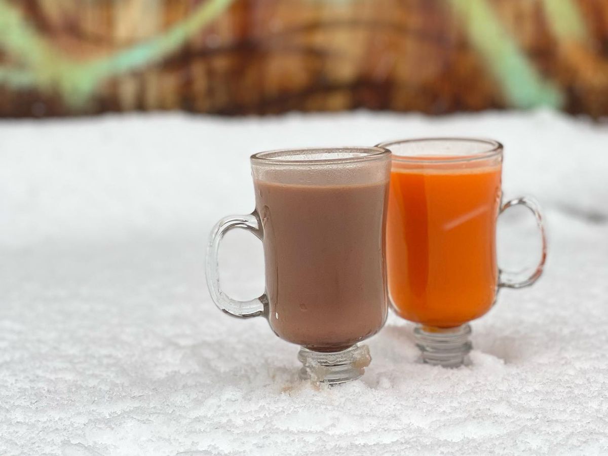 Rum cocktails in clear mugs sitting in snow 