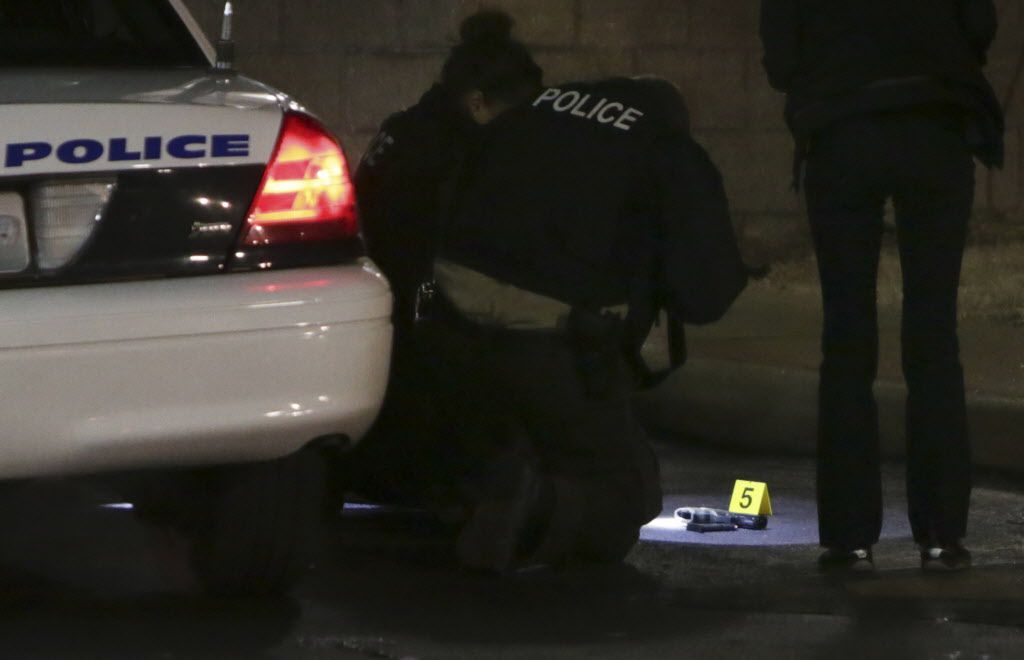 <small><strong>Police photograph a gun on the ground Wednesday, Dec. 24, 2014, following a shooting Tuesday at a gas station in Berkeley, Mo. St. Louis County police say a man who pulled a gun and pointed it at an officer has been killed.| David Carson / 