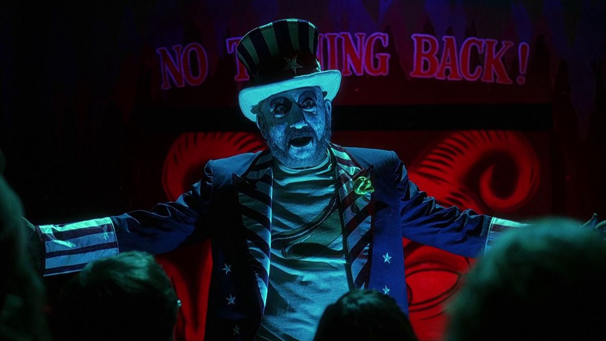 A man in a circus costume with a pale white face in House of 1000 Corpses.