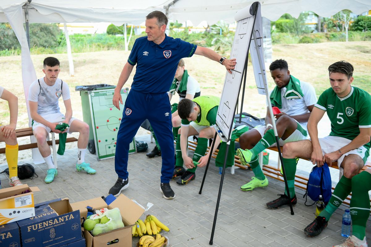 Manager outlines tactics to his players before an international match