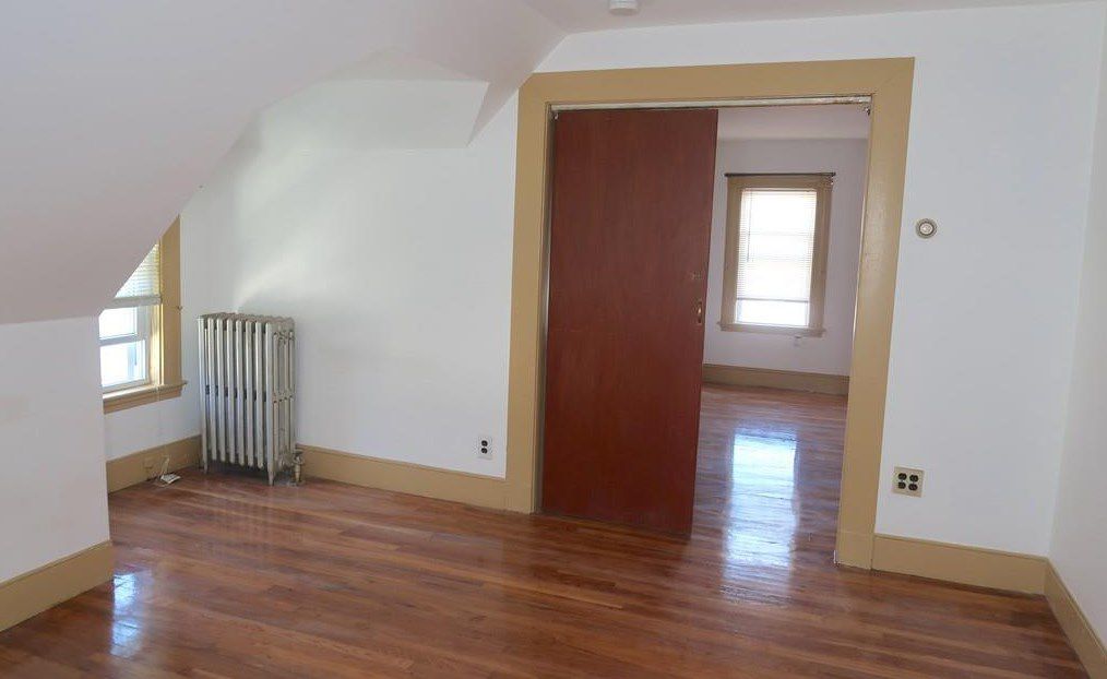 Two empty rooms separated by a partially opened sliding door. 