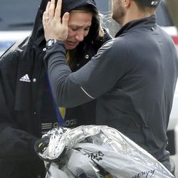 An unidentified Boston Marathon runner is comforted as she cries in the aftermath of two blasts which exploded near the finish line of the Boston Marathon in Boston, Monday, April 15, 2013.