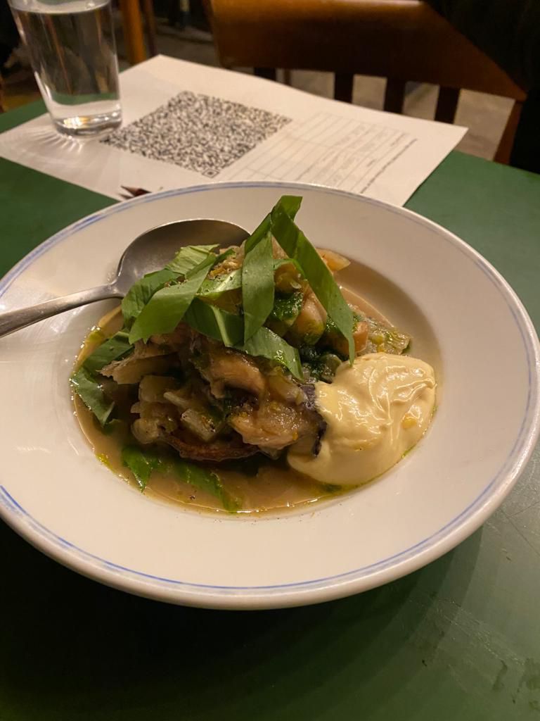 Braised cuttlefish and wild garlic on toast on a green table with a QR code in the background