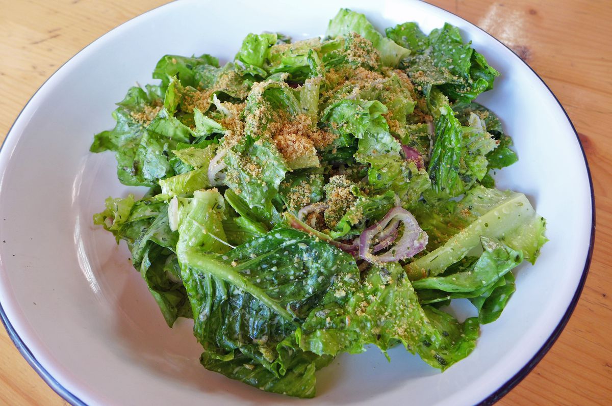 A green salad heaped with bread crumbs.