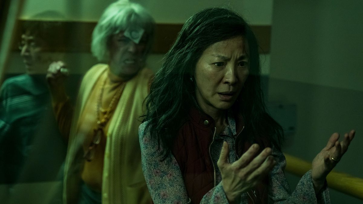 Michelle Yeoh examines her hands as Jamie Lee Curtis attacks from behind in Everything Everywhere All At Once
