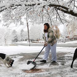 Meghan Doelling shovels her driveway with the help of her dogs, Stella and Zeke, in Centerville as Wasatch Front residents dealt with the first major snowstorm of the season on Monday, Nov. 28, 2016.