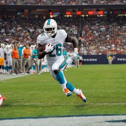 Aug 17, 2013; Houston, TX, USA; Miami Dolphins running back Lamar Miller (26) scores a touchdown during the first half against the Houston Texans at Reliant Stadium.