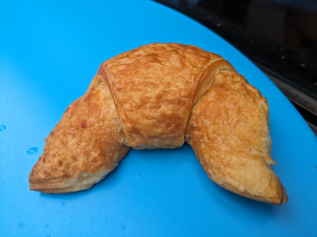 A simple croissant on a sky blue background.